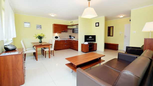 Un espacio habitable compacto con kitchenette, comedor y zona de estar.