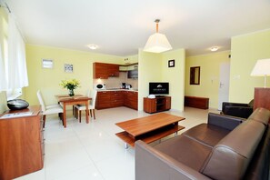 A compact living space with a kitchenette, a dining area, and a seating area.