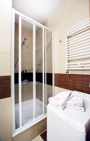 Appartement | Badkamer | Een douche, gratis toiletartikelen, een haardroger, handdoeken