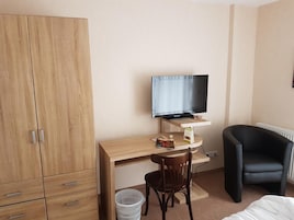 Minibar, escritorio, cortinas blackout y tabla de planchar con plancha 