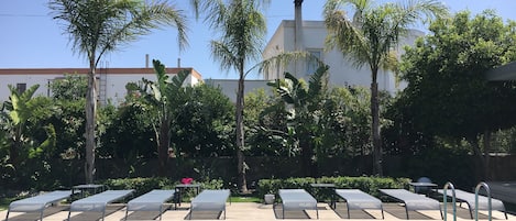 Piscine extérieure, parasols de plage, chaises longues