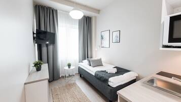 A modern bedroom with a bed, bedside table, and a built-in TV.