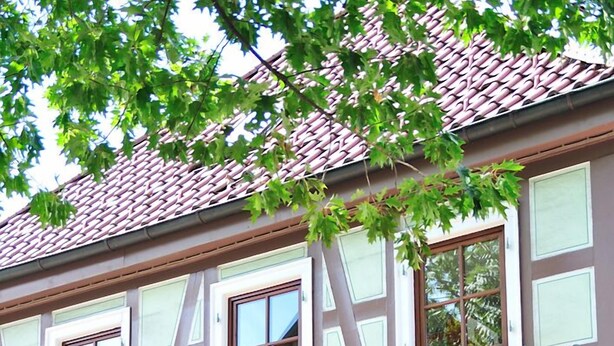Un restaurant d’hôtel appelé « Prinz », doté d’une façade traditionnelle à colombages, de grandes fenêtres et de jardinières placées sous les fenêtres.