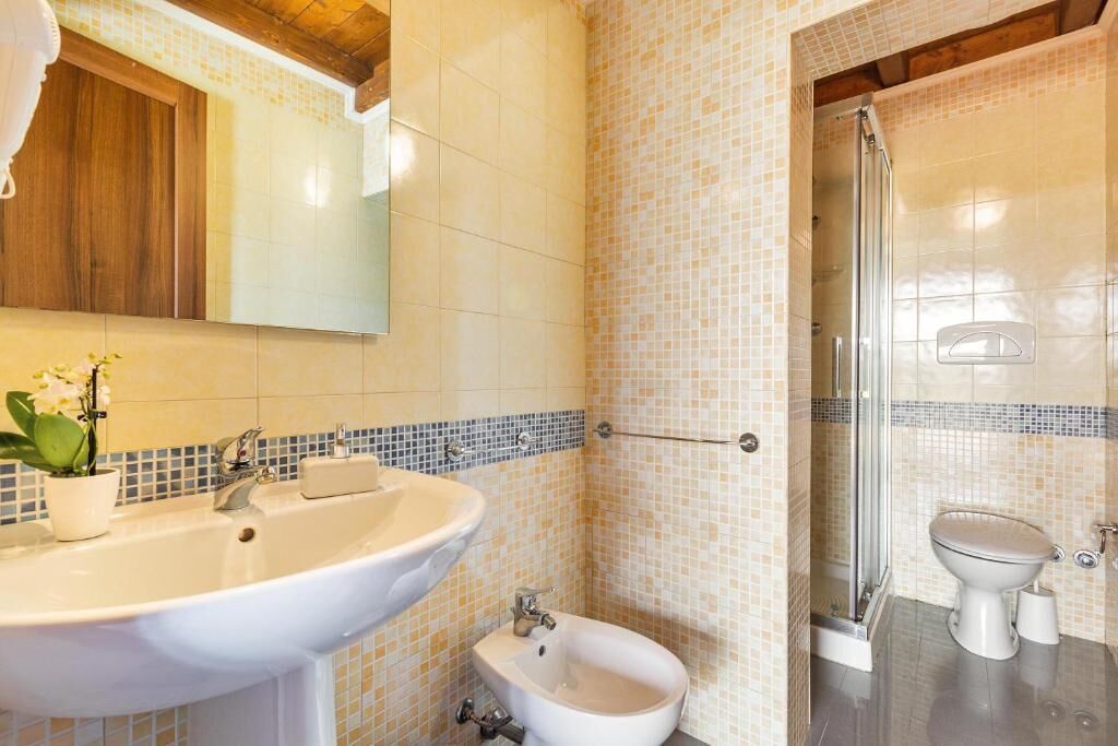 Un baño con lavamanos, bidé y ducha.