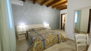 A bedroom with a bed, bedside tables, a chair, and a mirror. - Tenuta Cavalieri (Leverano)