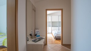 A bedroom with a bed, a bedside table with a mirror, and a window. - Villas Faro (Umag)