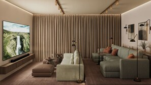 A modern living room with a large flat-screen TV, a sectional sofa, a coffee table, and a floor lamp. - 360 Hotel Boutique and Spa (Selfoss)