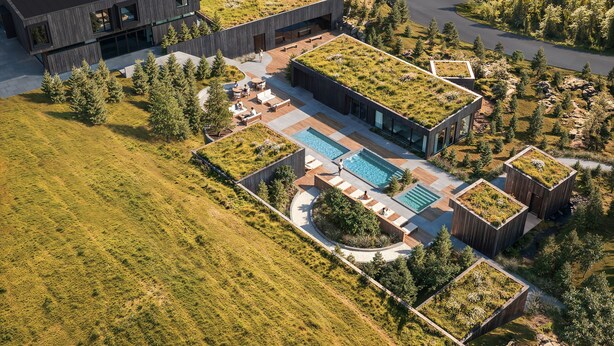 Un edificio moderno con un giardino pensile, una piscina e un'area esterna curata.