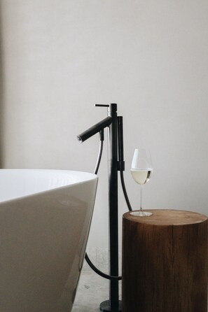 A minimalist room with a white table, a wooden stool, and a wine glass. - 360 Hotel Boutique and Spa (Selfoss)