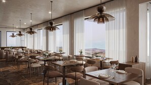 Un ristorante moderno con soffitti alti, ampie finestre e diverse disposizioni dei posti a sedere.