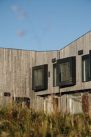 Un edificio moderno con fachada de madera y ventanas grandes.