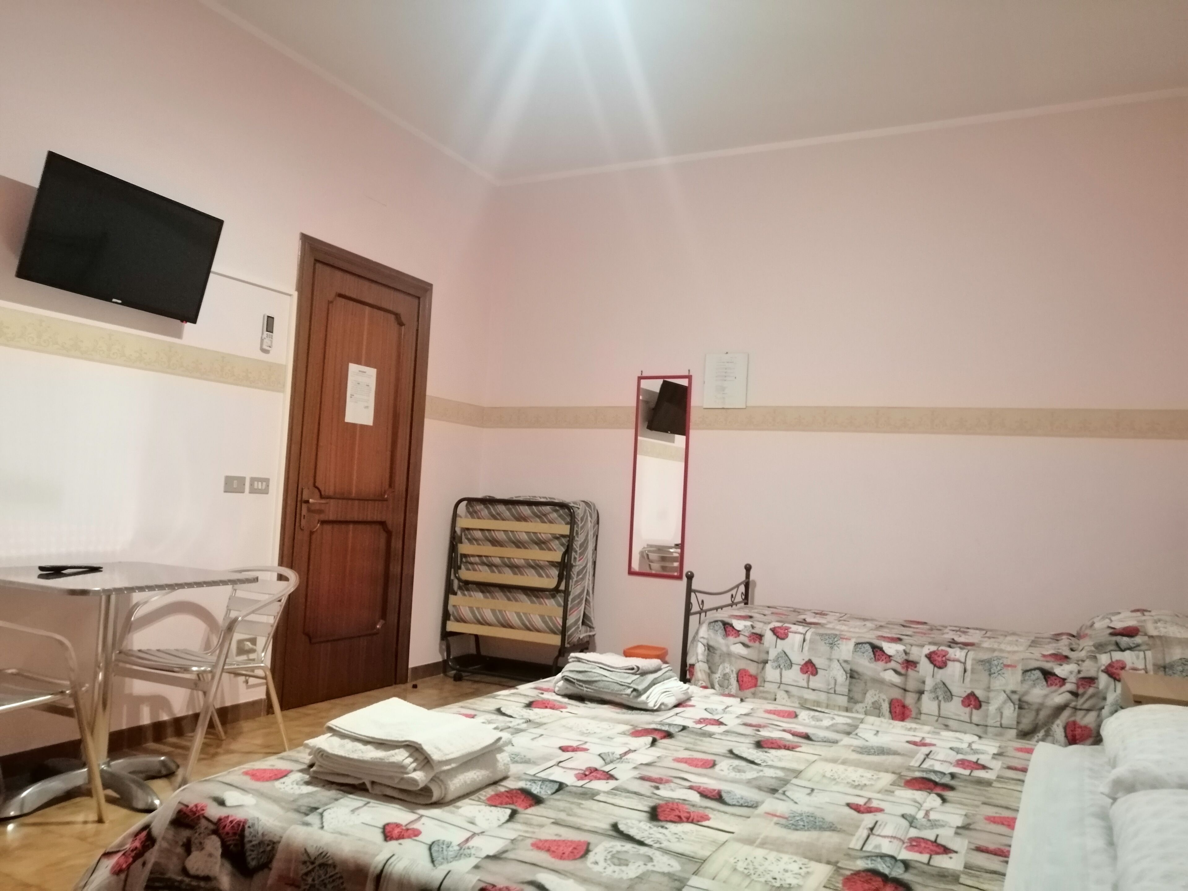 A room with a bed, a chair, a desk, and a television.