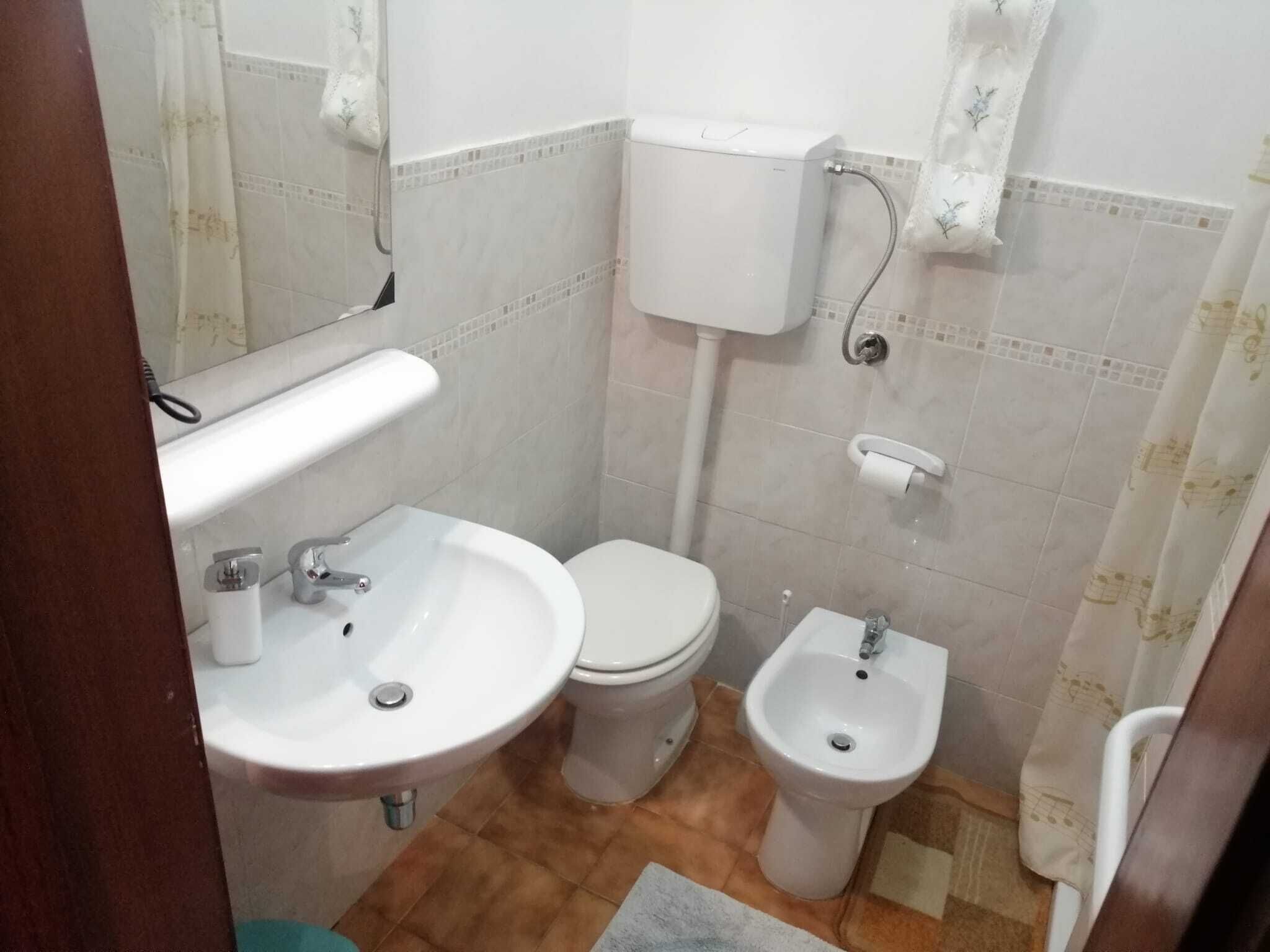 A bathroom with a toilet, bidet, and sink.