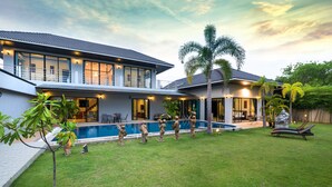 A modern two-story house with a swimming pool, a covered patio, and a well-maintained lawn. - Grand Villa Luxury Holidays Phuket (Choeng Thale)