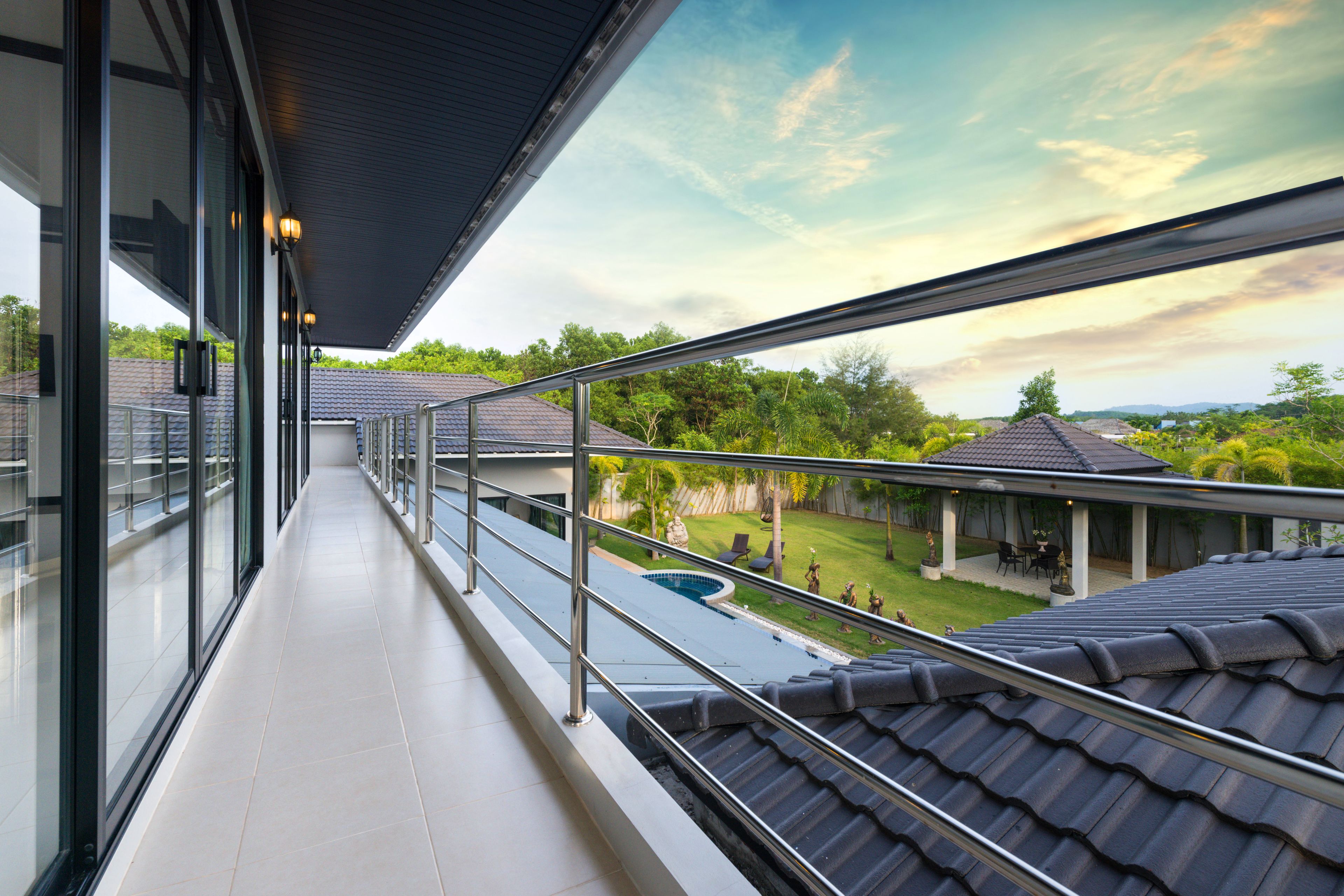 Ein Balkon mit Blick auf einen Swimmingpool und eine überdachte Terrasse.
