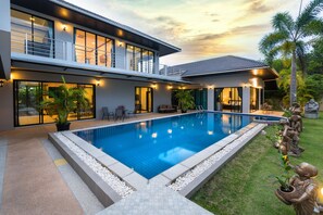 A modern two-story house with a swimming pool, outdoor seating, and a well-maintained garden. - Grand Villa Luxury Holidays Phuket (Choeng Thale)