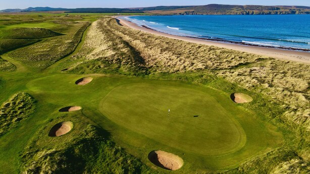 A golf course with bunkers, a beach, and a view of the ocean. - Another Place, The Machrie (Islay Island)