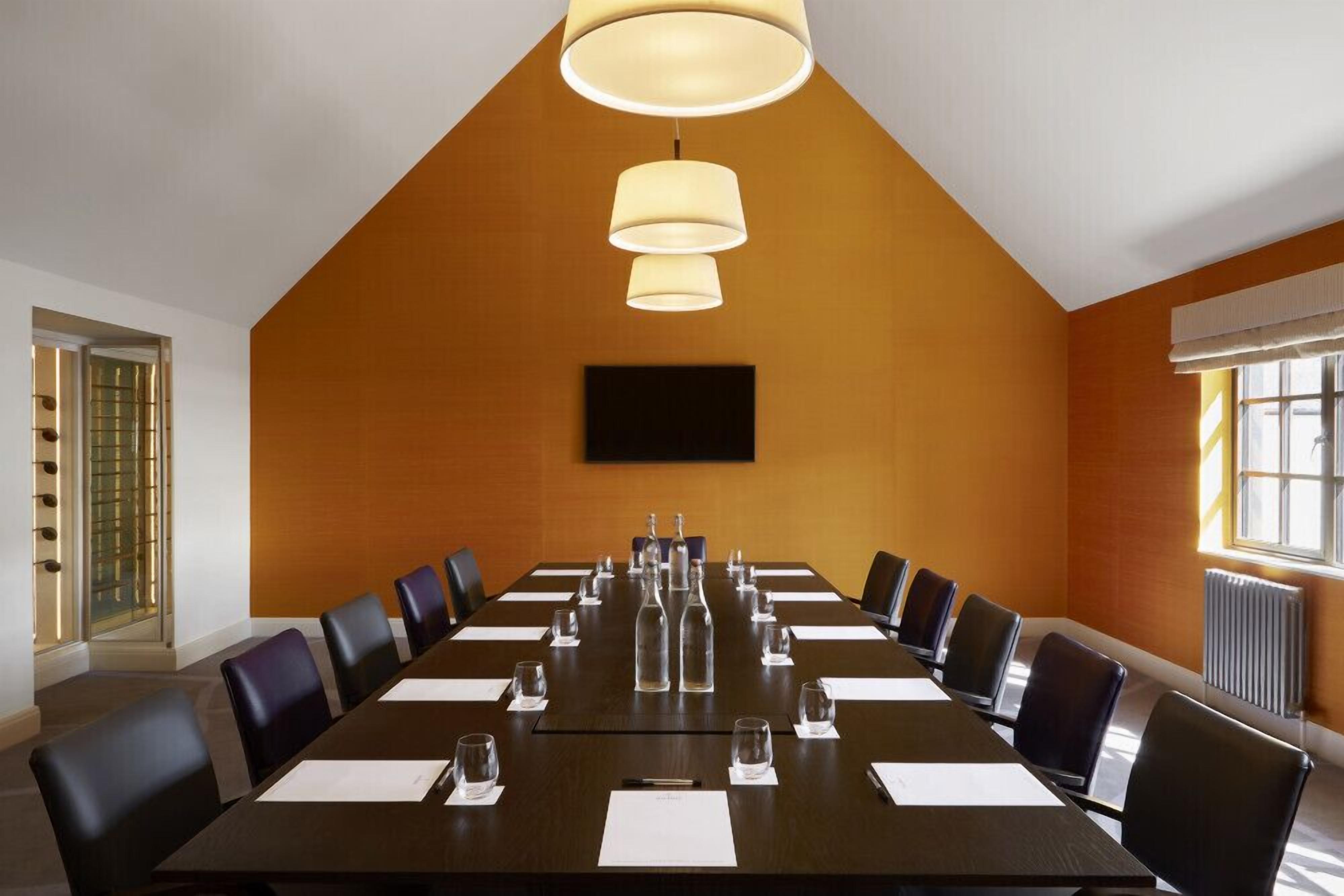 A conference room with a long table, chairs, and a large window.