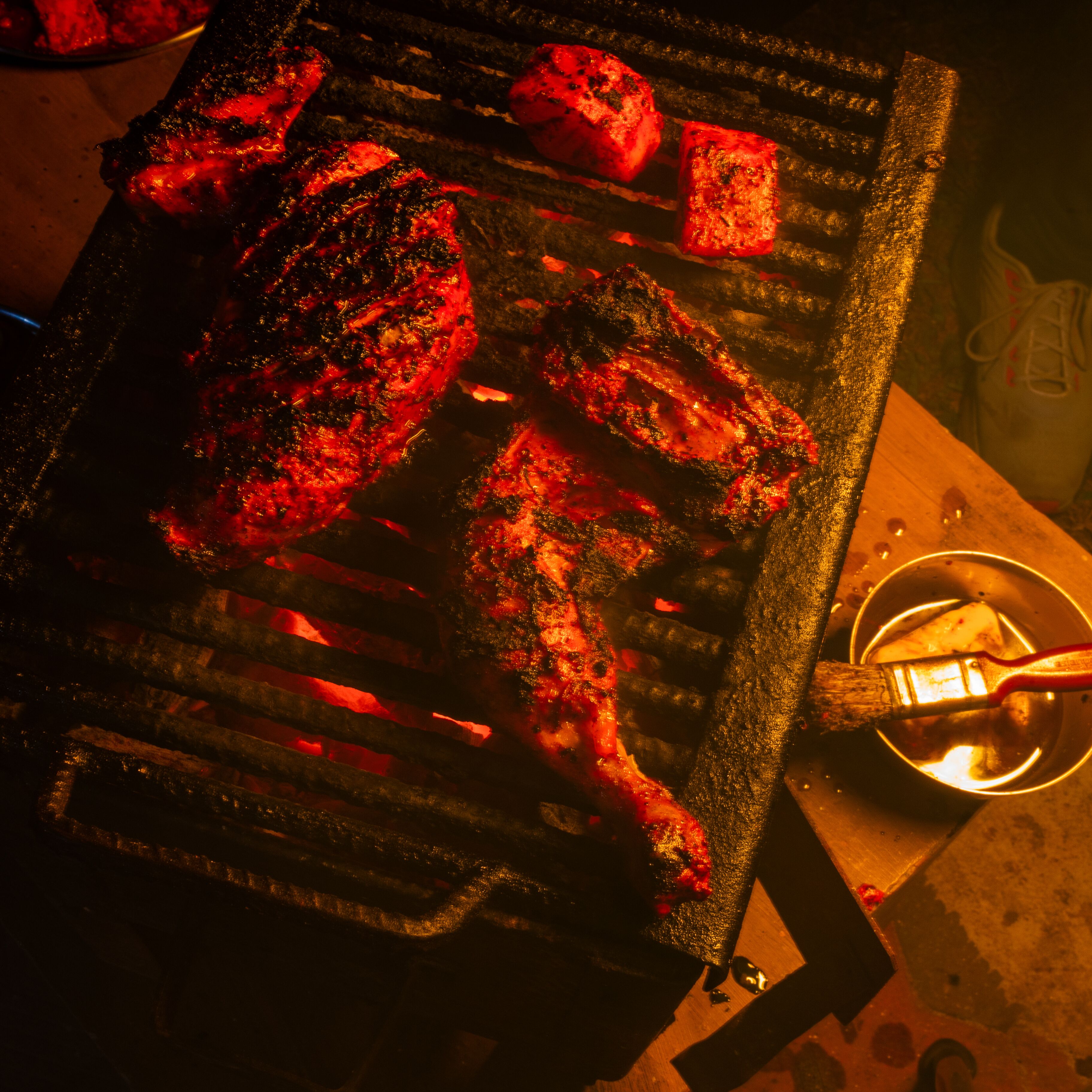 A grill with several pieces of meat being cooked.