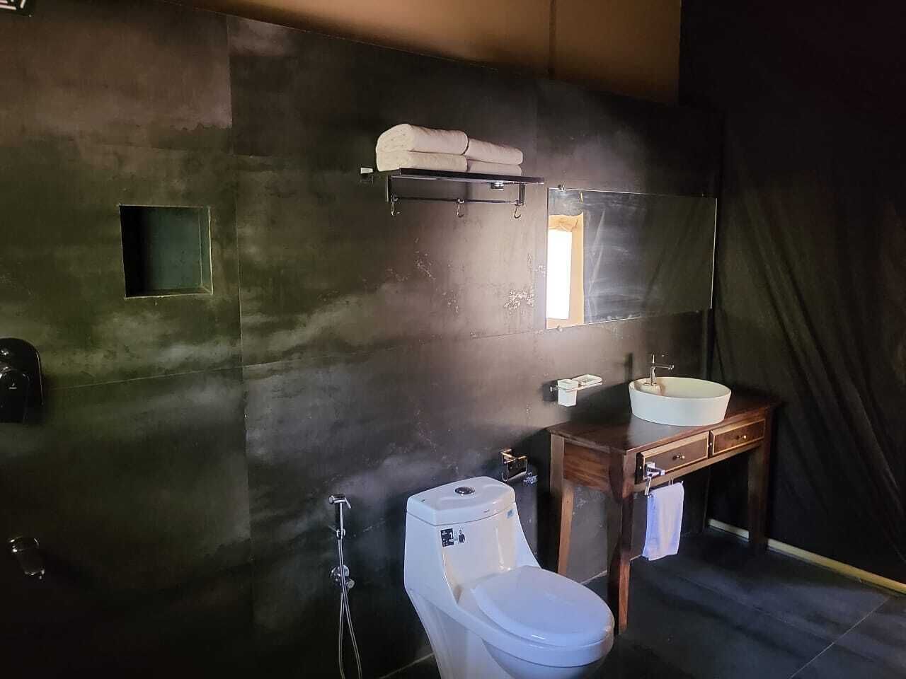 A bathroom with a toilet, sink, and towel rack.