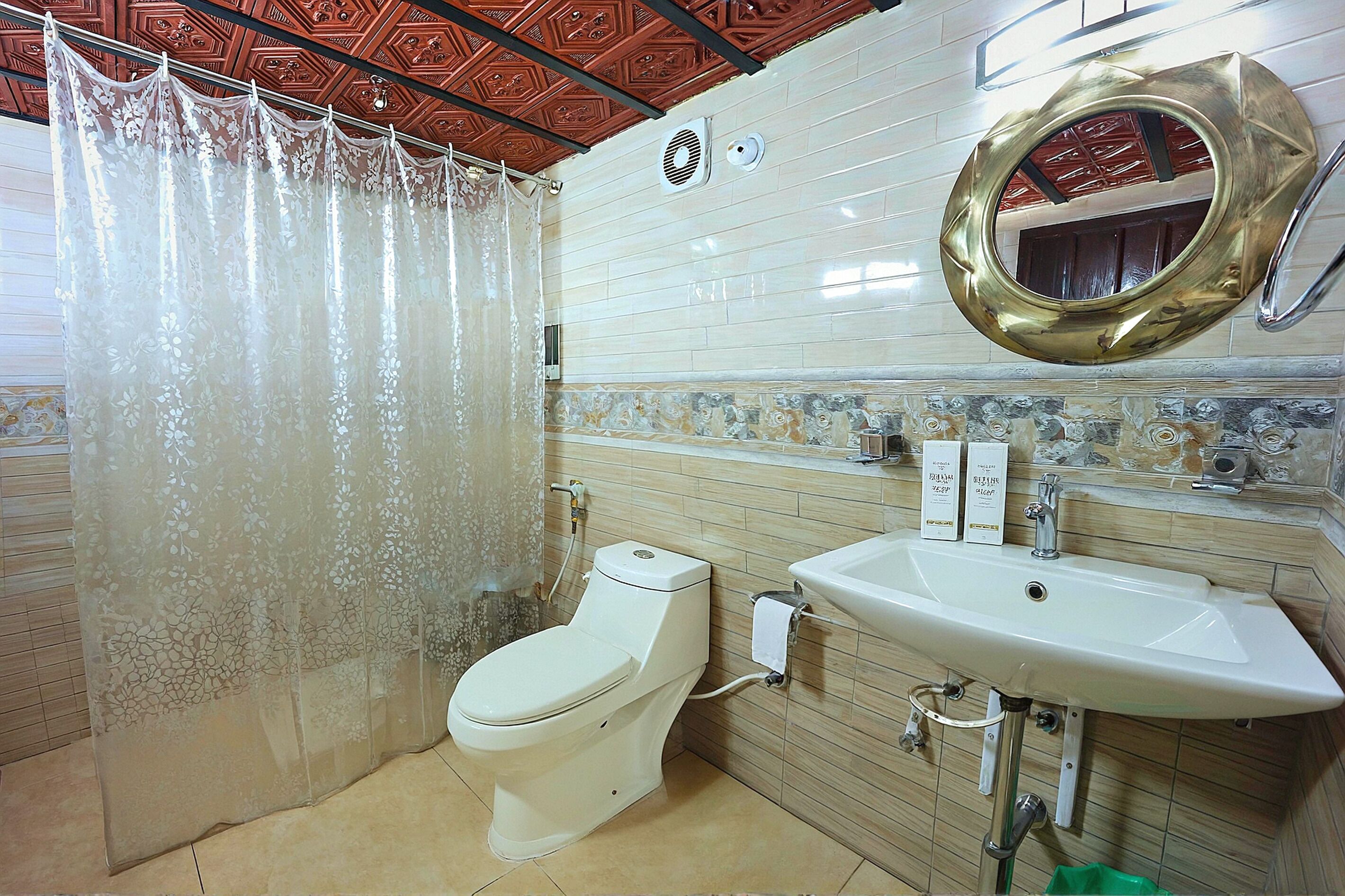 Une salle de bain équipée de toilettes, d’un lavabo et d’un rideau de douche.
