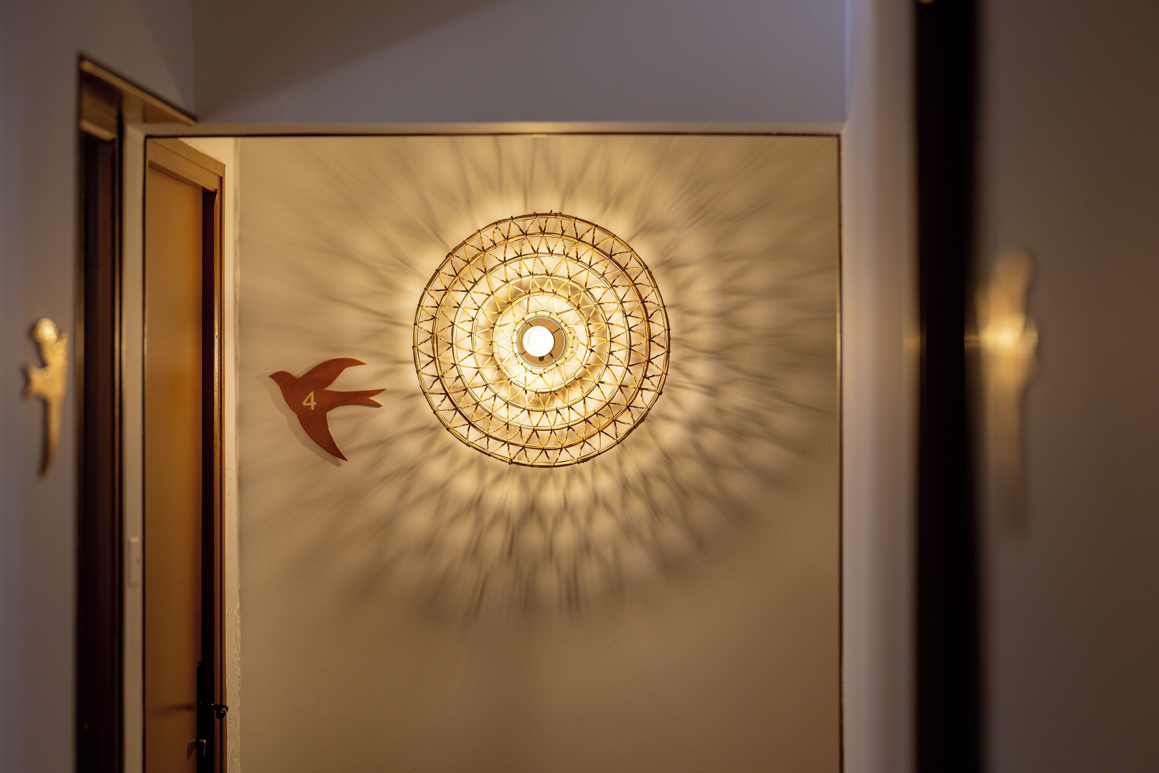 A wall with a geometric light fixture and a directional arrow sign.
