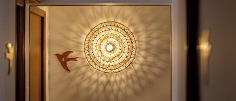 A wall with a geometric light fixture and a directional arrow sign.