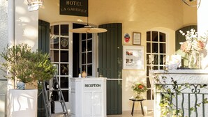 A hotel reception area with a reception desk, a sign above it, and a window with a view.