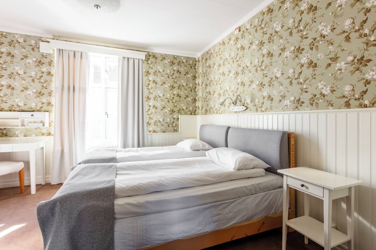Ein Schlafzimmer mit zwei Betten, einem Schreibtisch und einem Stuhl.
