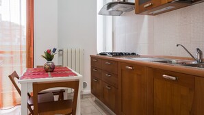 Een keuken met houten kastjes, een fornuis en een spoelbak.