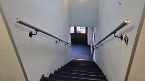 Una escalera con barandillas de metal y un accesorio de iluminación en la parte superior.