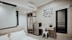 Un dormitorio moderno con una cama, un escritorio y una silla. Hay una pared con una frase motivacional.