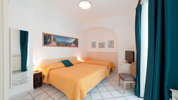 Une chambre d’hôtel avec deux lits, une télévision et un petit bureau.