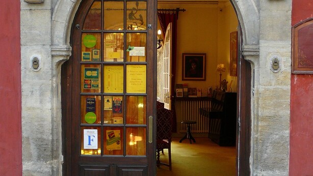 A hotel entrance with a large arched doorway, a number '153' above it, and a sign indicating a 'F' rating. - Hotel Du Fiacre (Carpentras)