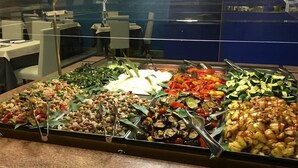 Un buffet con diversi piatti, tra cui insalate, verdure e carni.