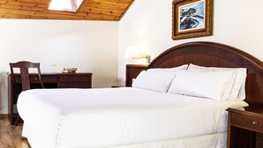 A bedroom with a wooden ceiling, a bed with white linens, a desk with books, a chair, and a framed picture on the wall. - Balneario  Caldas de Luna (Sena de Luna)