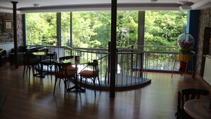 A spacious room with a large window, a round table, and a chair. - Balneario  Caldas de Luna (Sena de Luna)