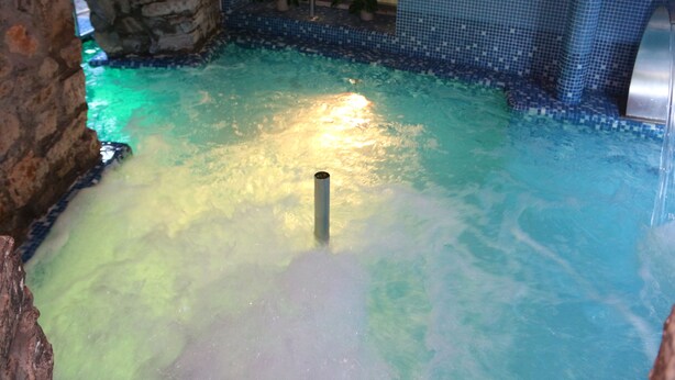 A pool with clear water, a stone wall, and a tiled border. - Balneario  Caldas de Luna (Sena de Luna)