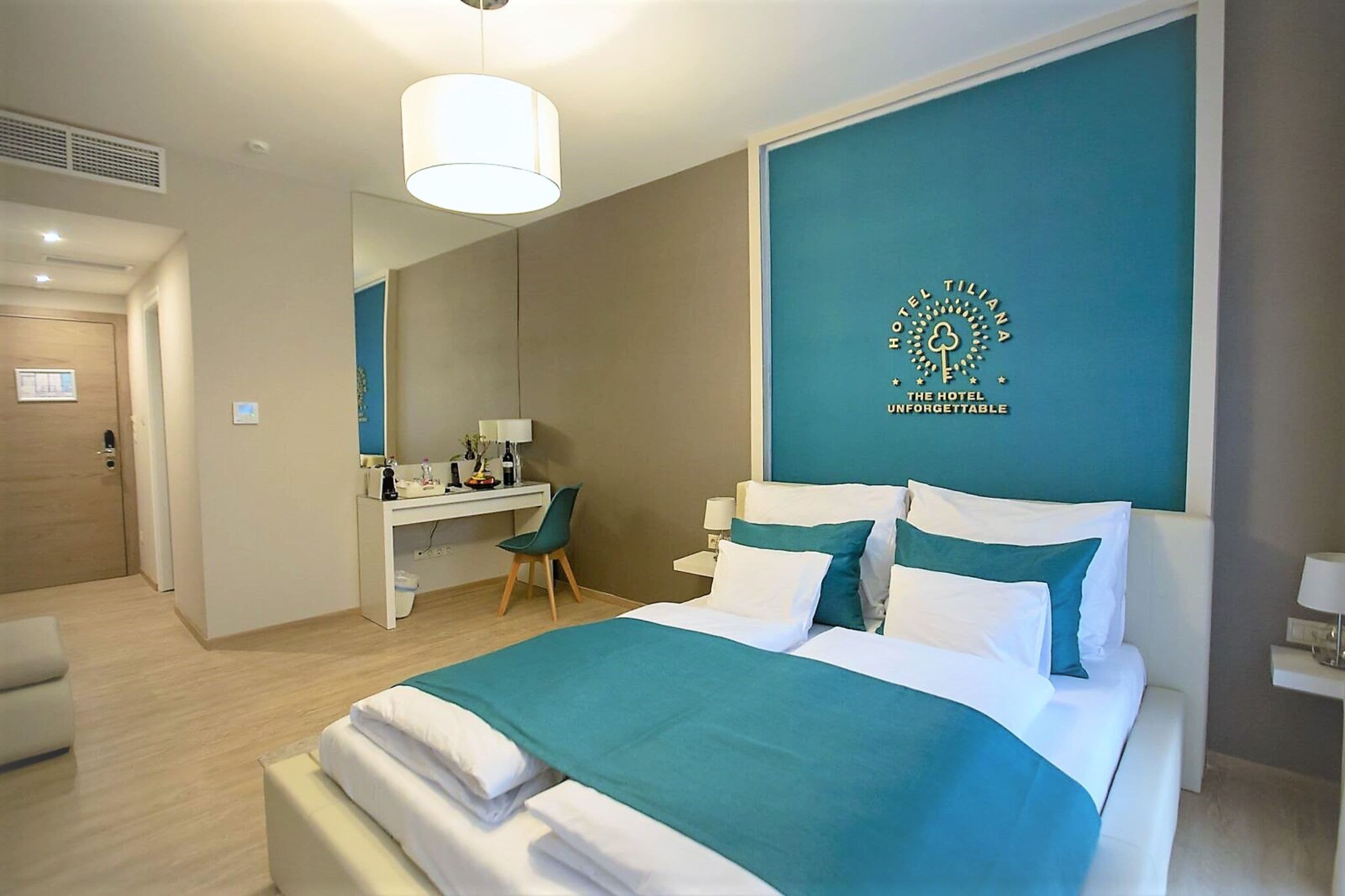 Una habitación de hotel moderna con cama, escritorio y un espejo grande.