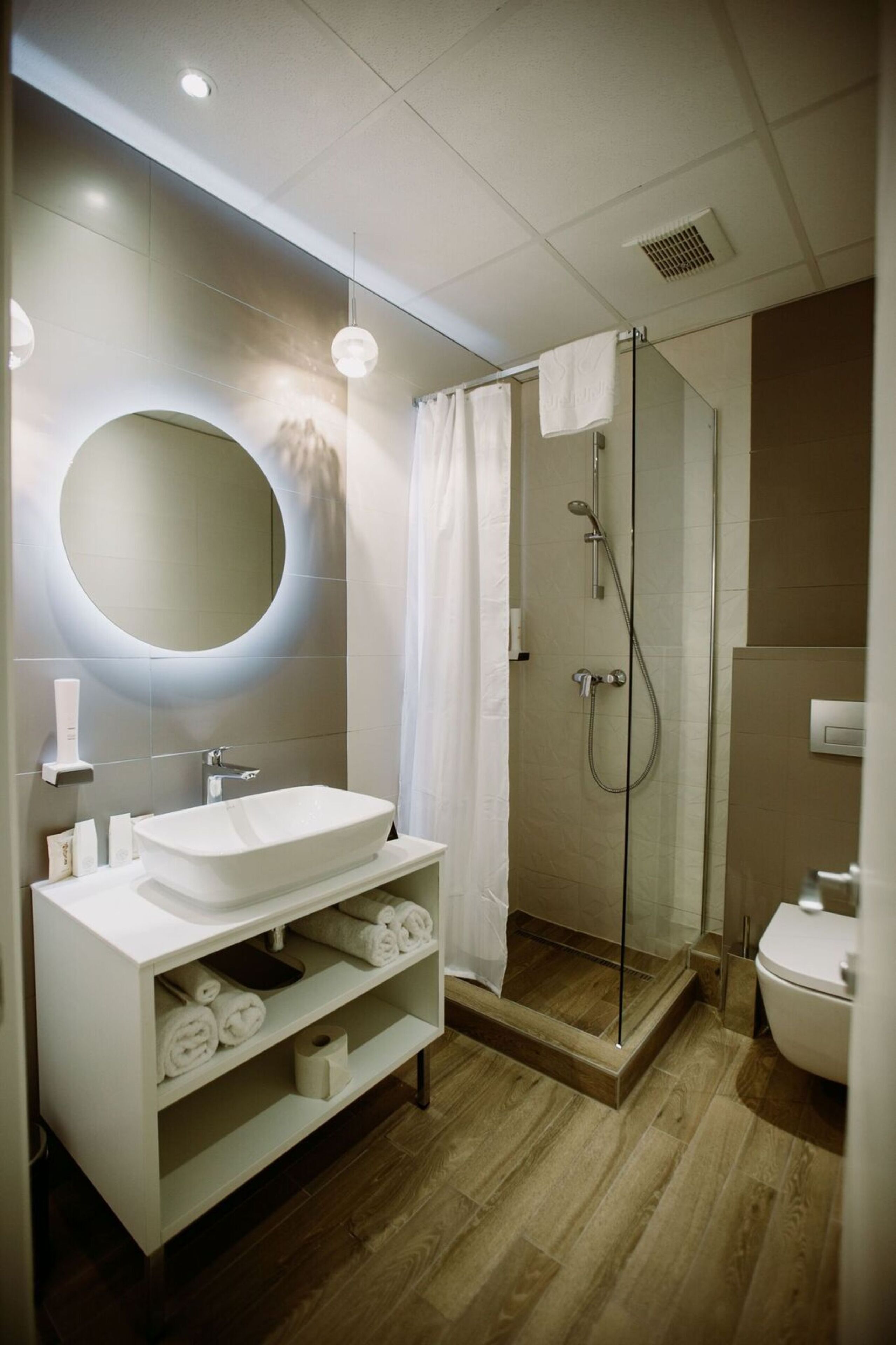 Une salle de bain moderne avec une baignoire sur pieds, une douche à parois de verre et un grand miroir.