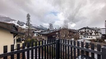 A residential area with traditional wooden houses, a wooden fence, and a mountainous backdrop.