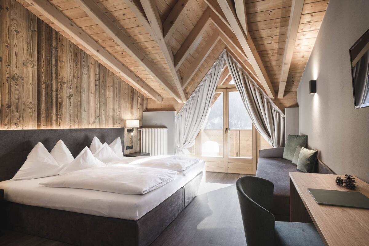 Un dormitorio moderno con una cama grande, un escritorio y una silla.