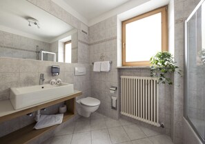 A modern bathroom with a large sink, toilet, and shower.