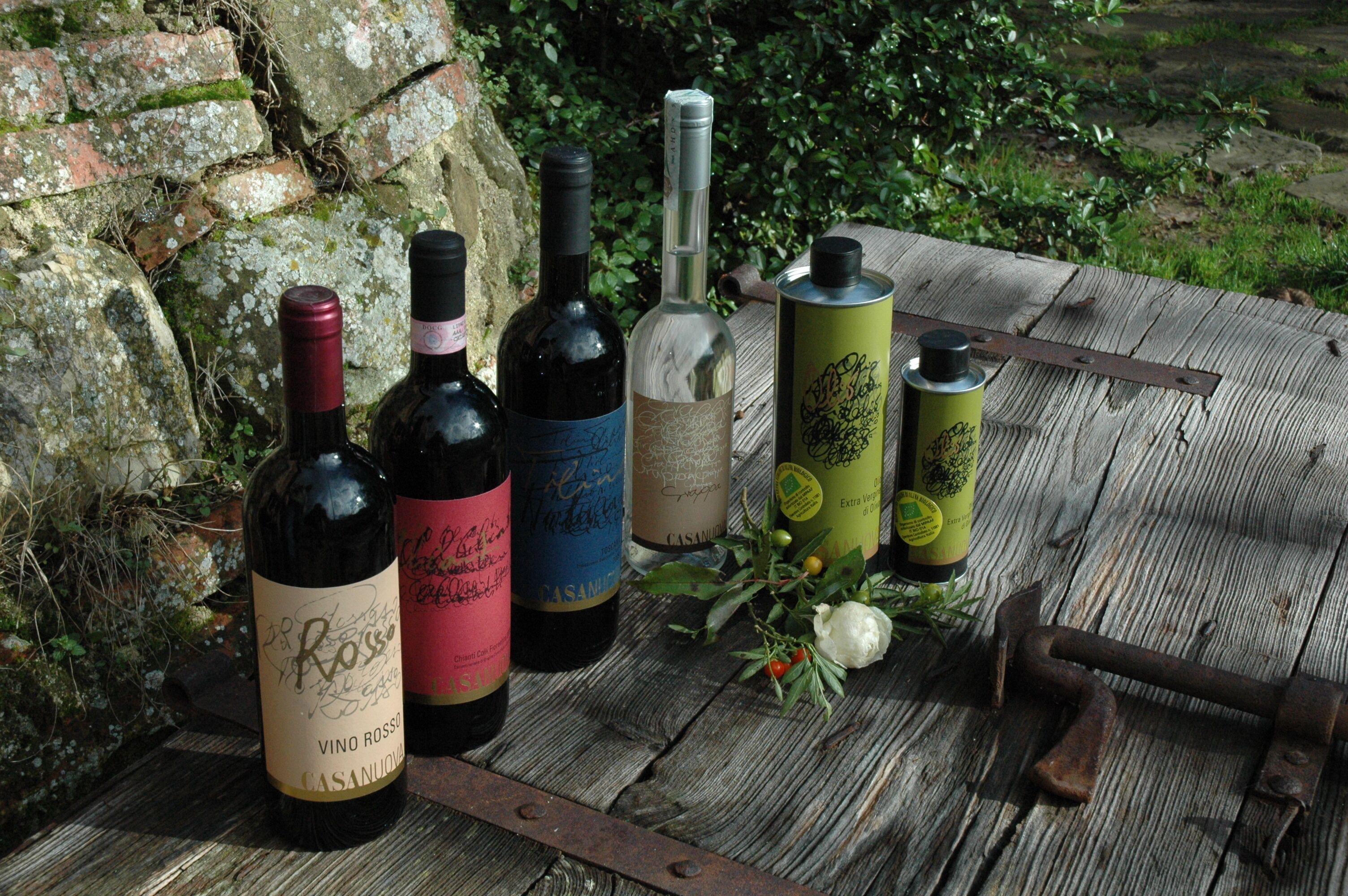 Une table en bois, avec des bouteilles de vin et un récipient en métal.