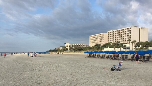 Une plage avec un hôtel en arrière-plan.