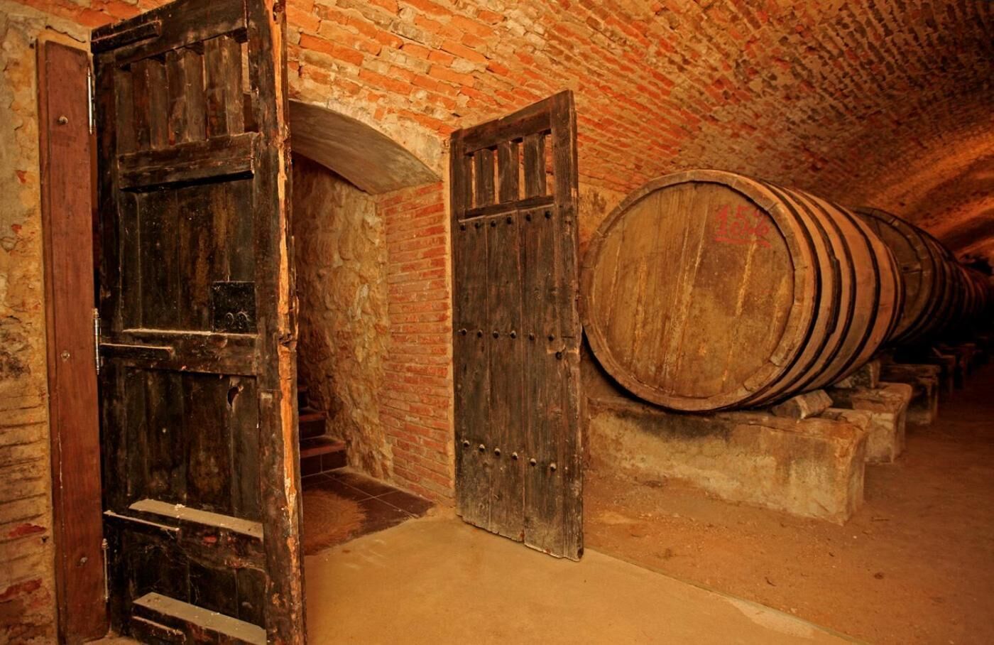 A cellar with wooden doors and barrels, suggesting a historical or traditional setting.