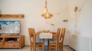 Un espace repas comprenant une table en bois, des chaises et un luminaire suspendu.