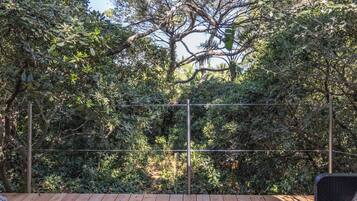 Une vue d’un jardin, avec un feuillage dense et une clôture en métal.