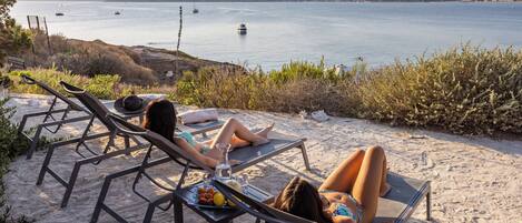 På stranden, solsenger og parasoller