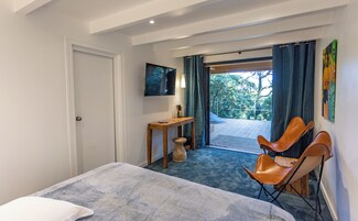 Une chambre d’hôtel équipée d’un lit, d’un bureau, d’une chaise, d’une télévision et offrant une vue sur l’extérieur.
